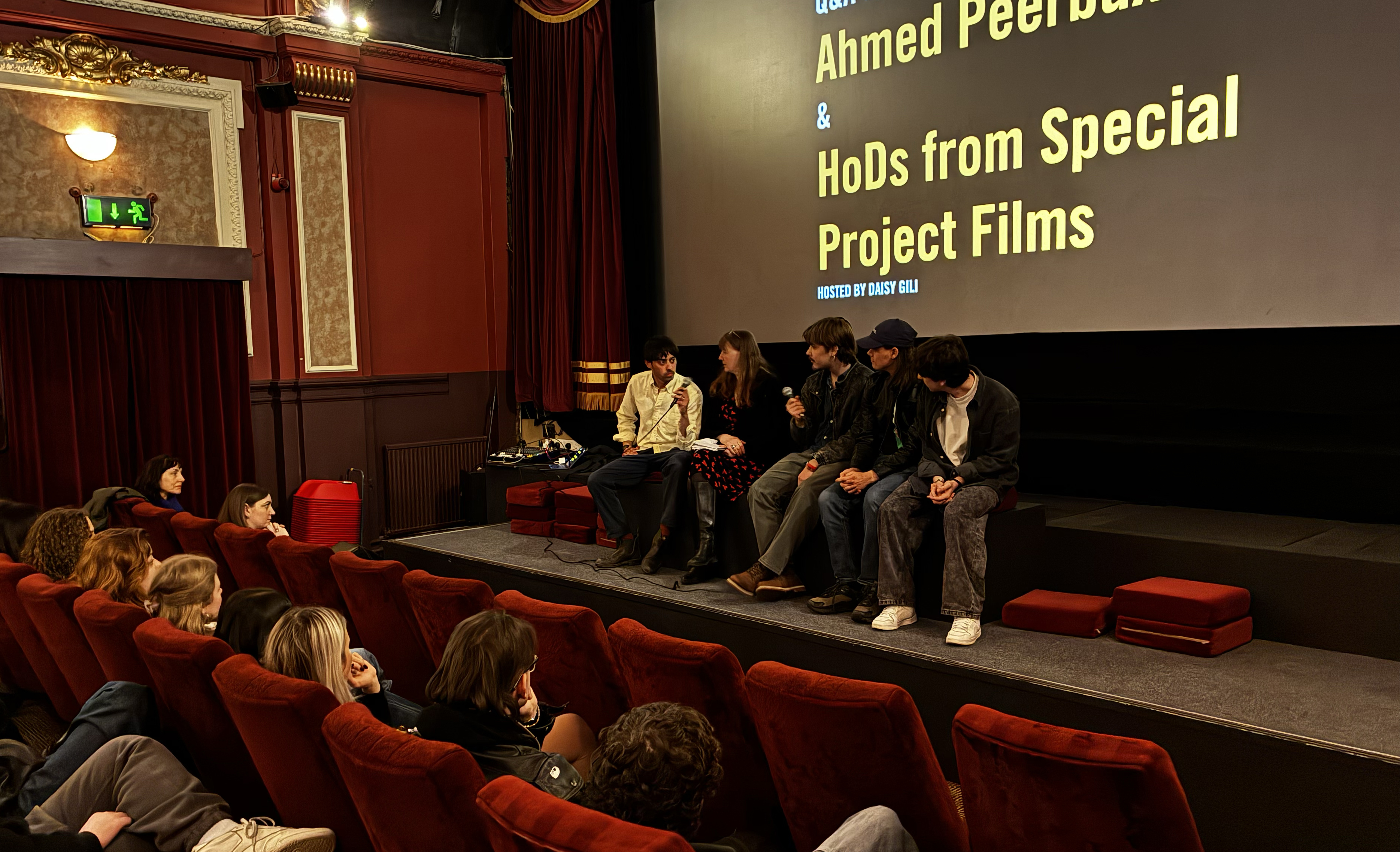 Group of panellists on cinema stage, talking